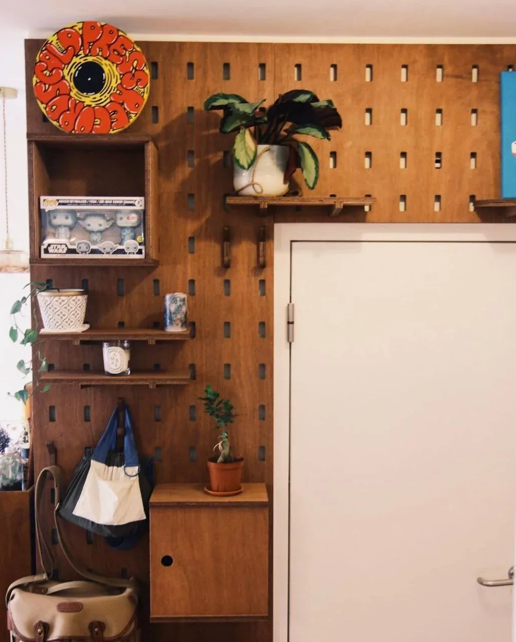SNUG plywood pegboard with shelves and personal objects