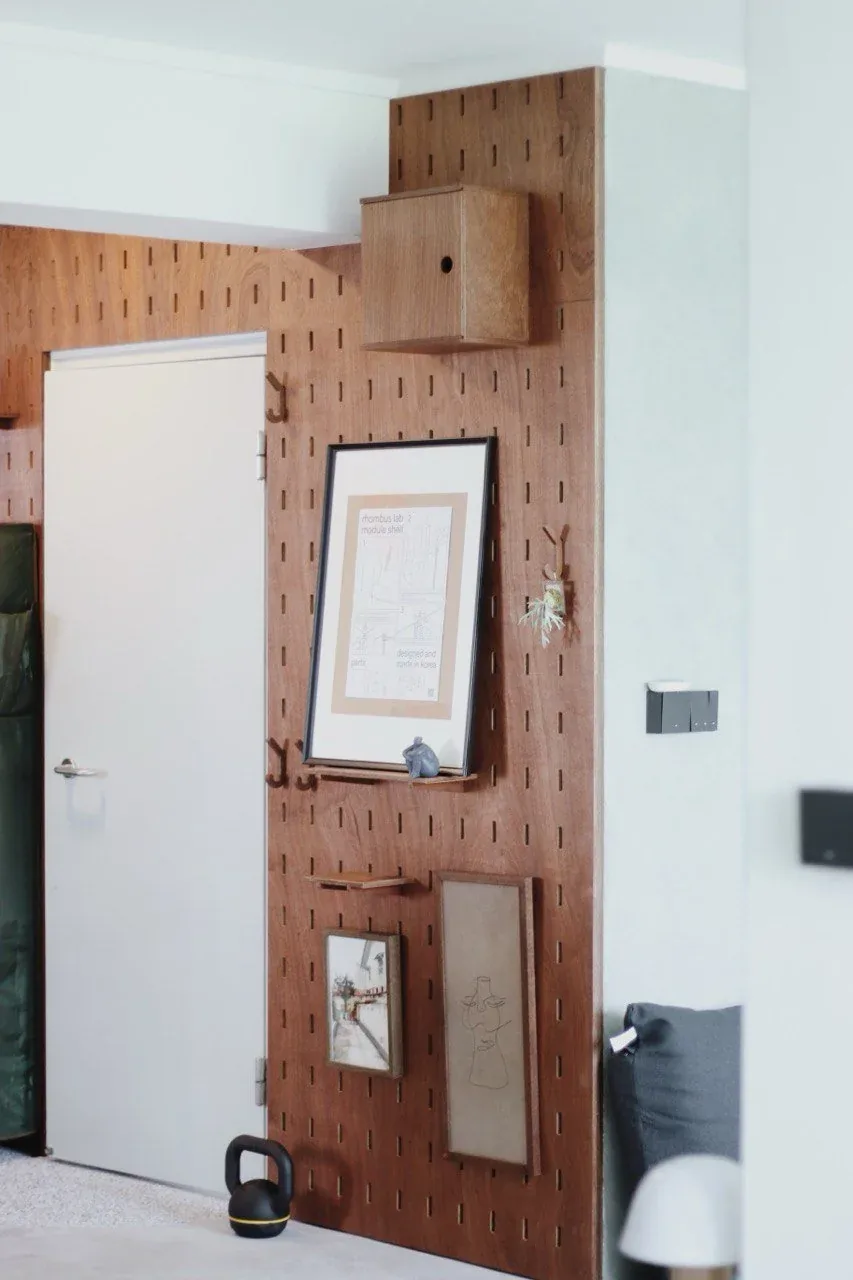 SNUG pegboard beside a doorway, with a box shelf and hanging frames